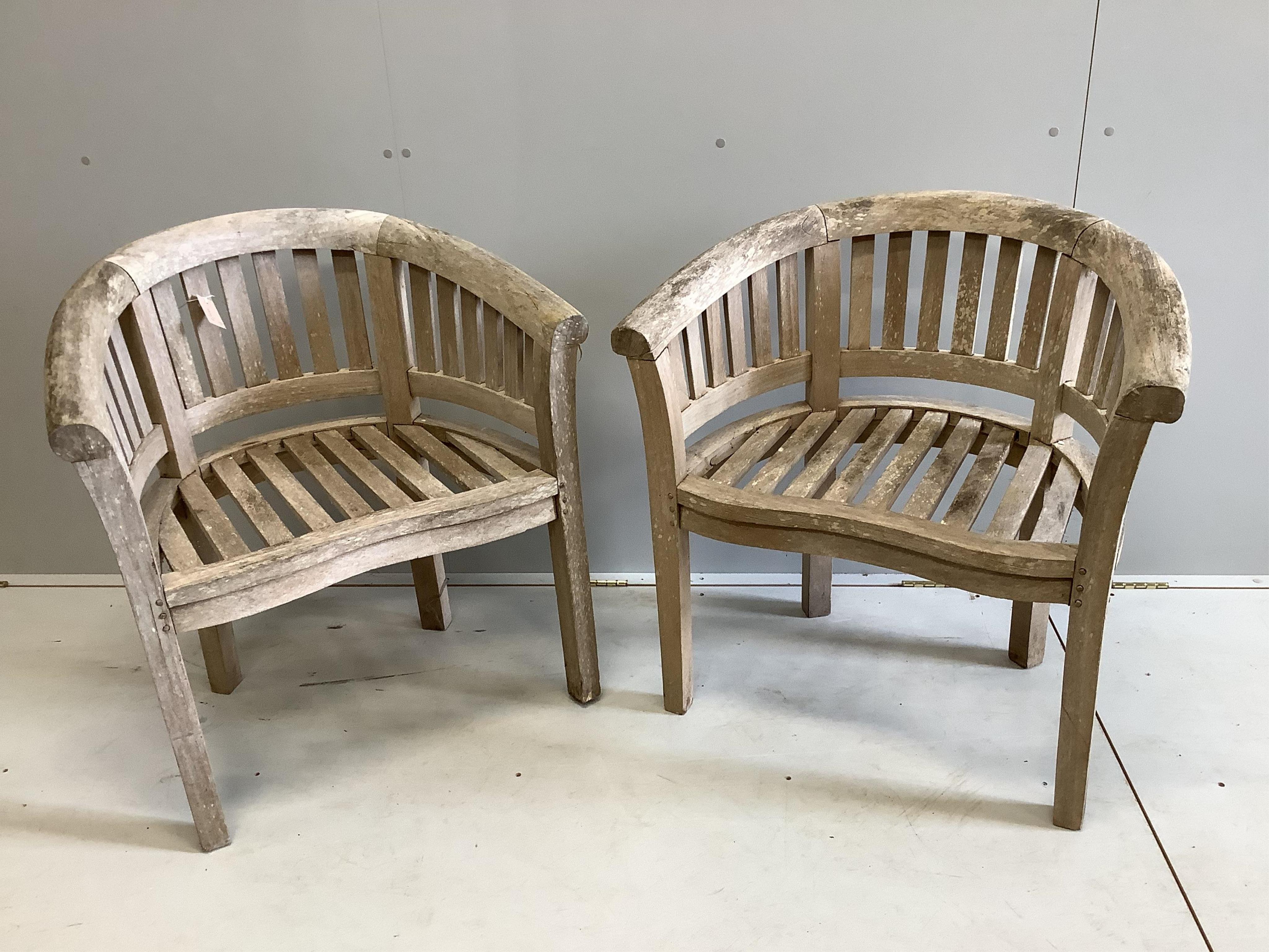A pair of weathered teak garden 'banana' chairs, width 78cm, depth 52cm, height 82cm. Condition - fair